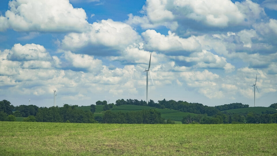 wind turbine in a field on a sunny day