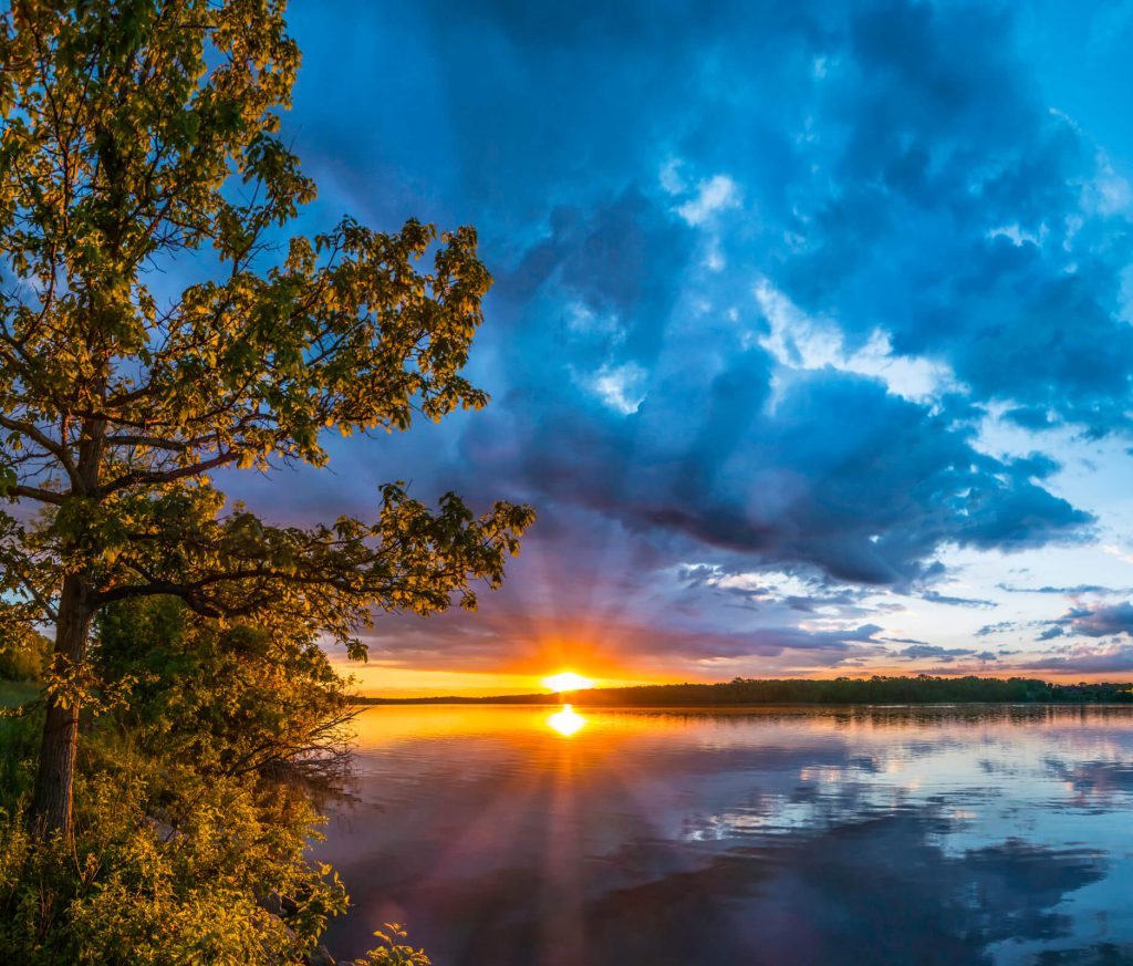 Sunrise bursts from beneath heavy clouds