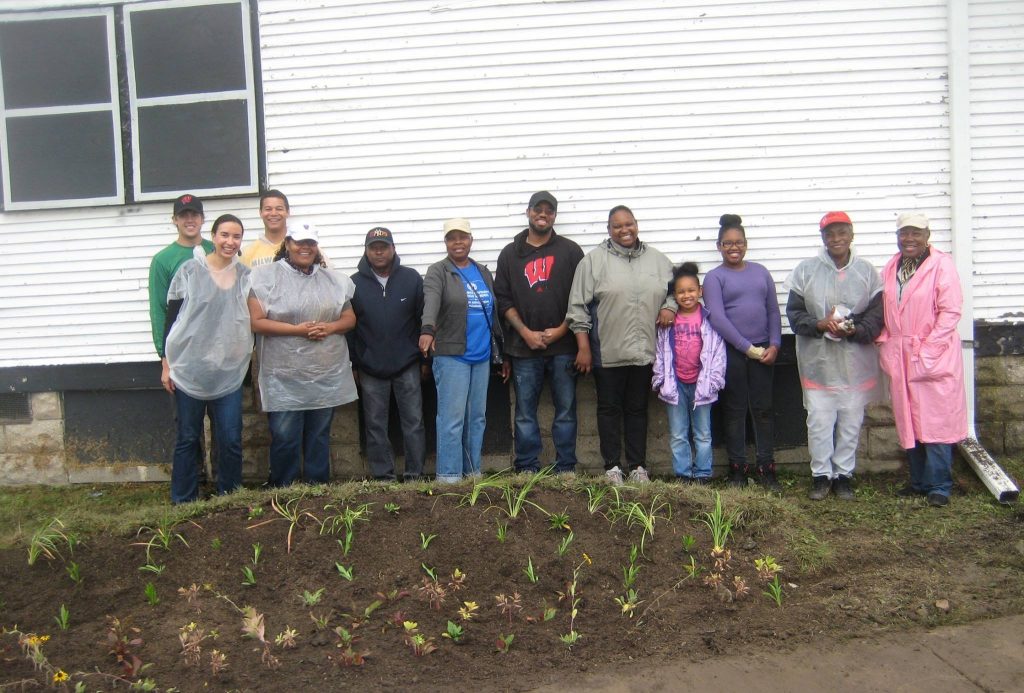 A group shot of Milwaukee community members with the rain garden they recently planted