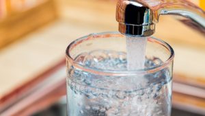 Filling up a glass with drinking water from kitchen tap