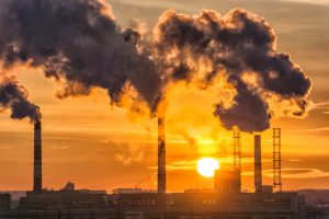 Power plant smoke stacks at sunset