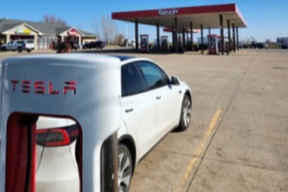 Tesla EV car charging at a charging station