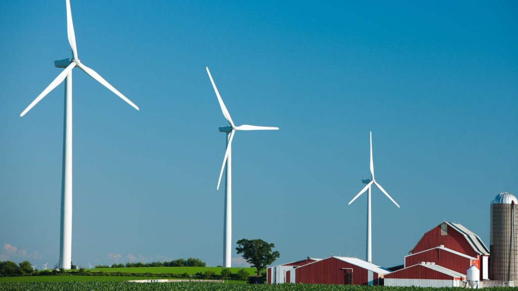 Wind turbines near a red barn