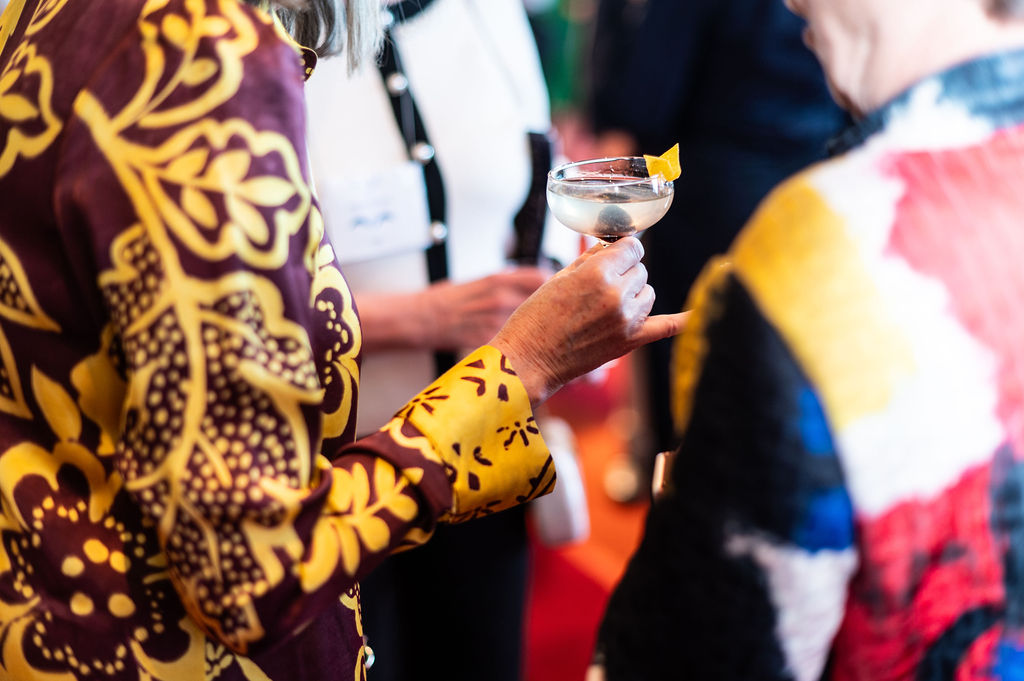 Someone holds a drink during the Epicurean Evening cocktail hour