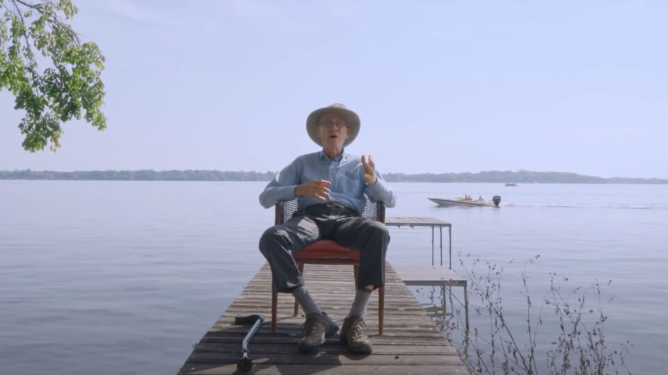 doug la follete sitting in front of lake mendota, speaking at the camera