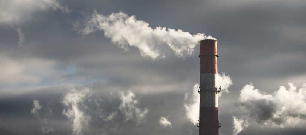 Panoramic view of power plant smokestack in dramatic light