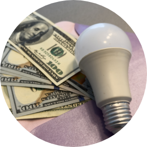 An envelope of money beneath an LED lightbulb
