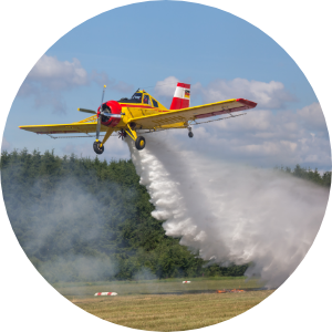 A plane dropping firefighting foam on a field