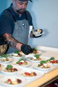Chef Evan Dannells plating dishes at Clean Wisconsin’s 2025 Epicurean Evening gala