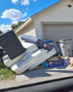 Water-damaged items from Maxie Addison’s basement sit on the curb after the 2025 floods